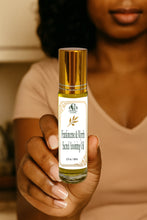Load image into Gallery viewer, Person holding a bottle of Frankincense & Myrrh Sacred Anointing Oil with a blurred background